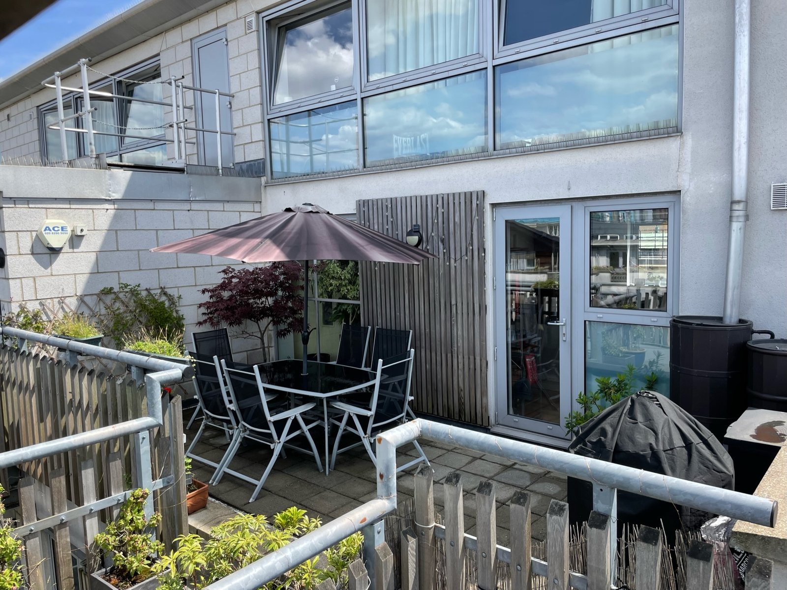 Courtyard terrace with spiral staircase up to a second level and outdoor dining