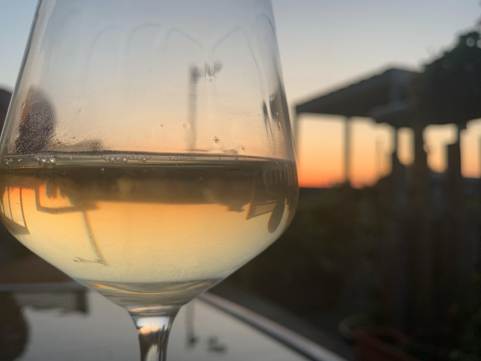 A glass of white wine on the terrace as the sun sets